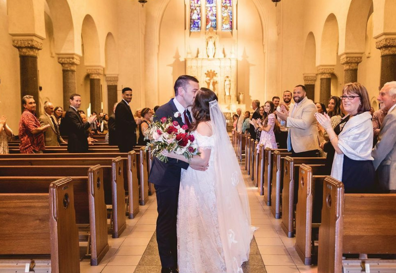 A wedding couple kisses in the chapel