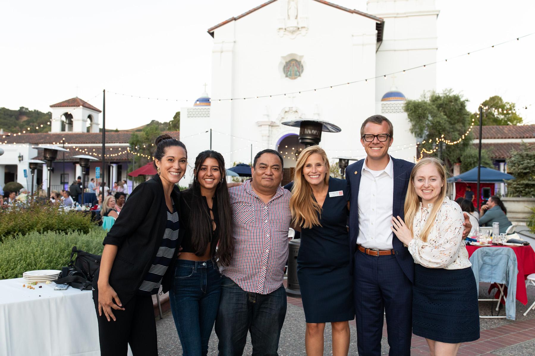 Saint Mary's alumni smiling in front of the chapel