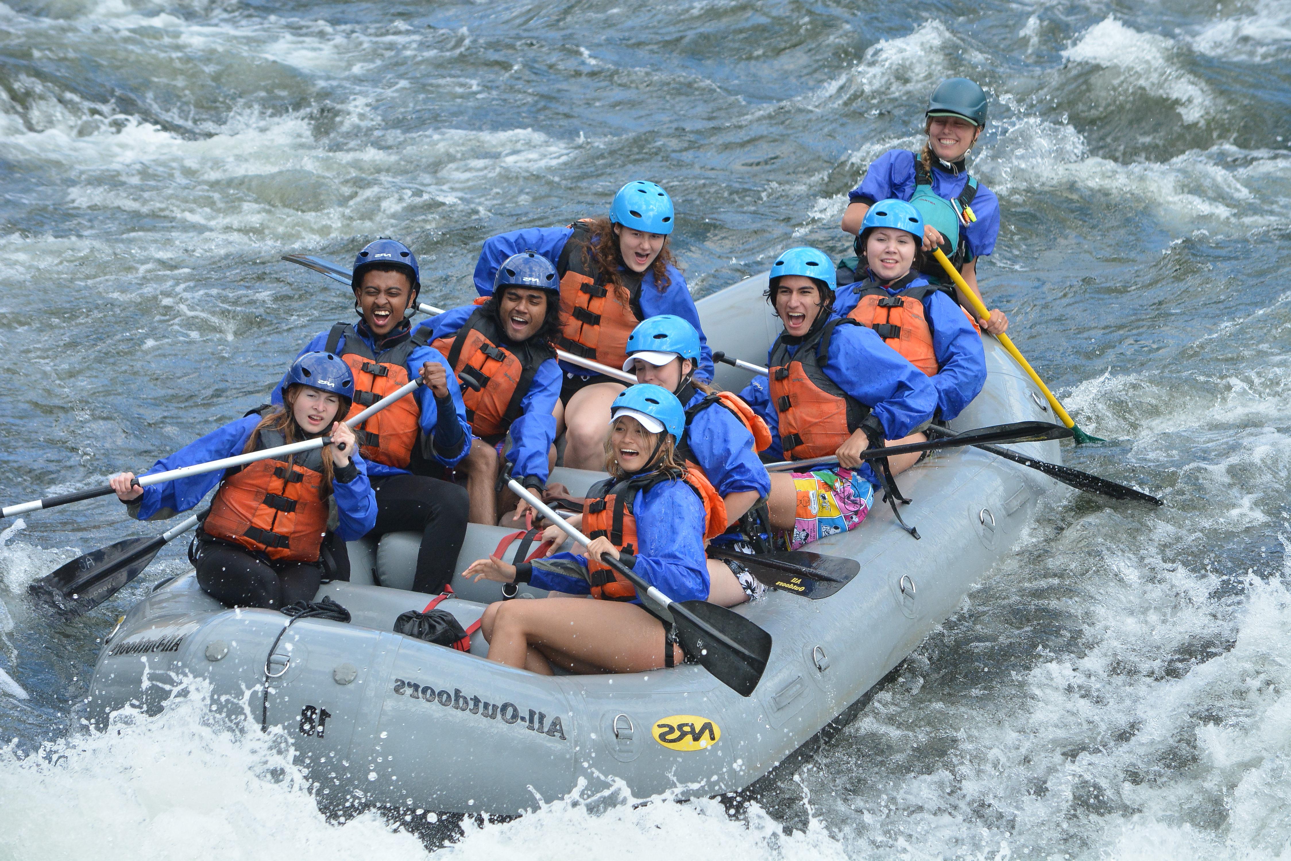 Student in rafting boats going down a rapid