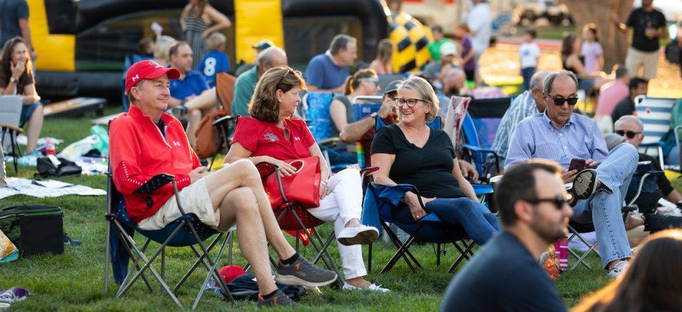 Four people sit and talk outside at Music on the Lawn