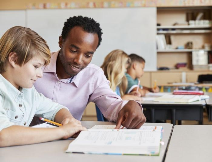 Male teacher teaching a student in the classroom